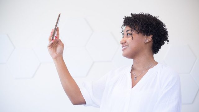 Une jeune femme souriante en appel vidéo sur son téléphone